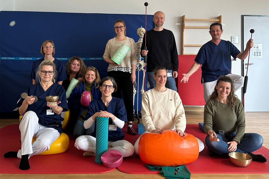 Team der Schmerztagesklinik steht in Turnhalle zum Gruppenfoto zusammen