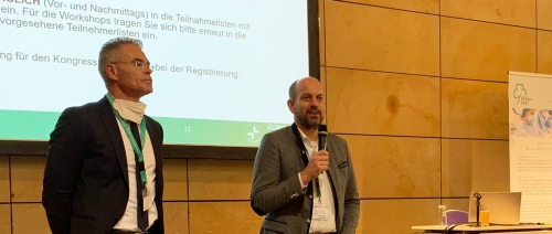 Prof. Dr. Harald Rittger und Prof. Dr. Raspé auf der Veranstaltungsbühne