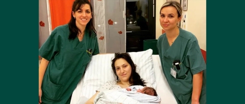 Hebammen stehen am Bett der Mama mit Neujahrsbabys  