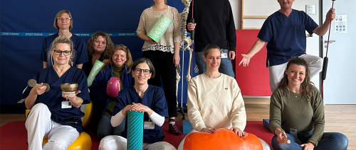 Team der Schmerztagesklinik steht in Turnhalle zum Gruppenfoto zusammen