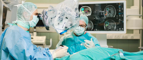 Prof. Dr. Brandner schaut bei OP durch das Mikroskop
