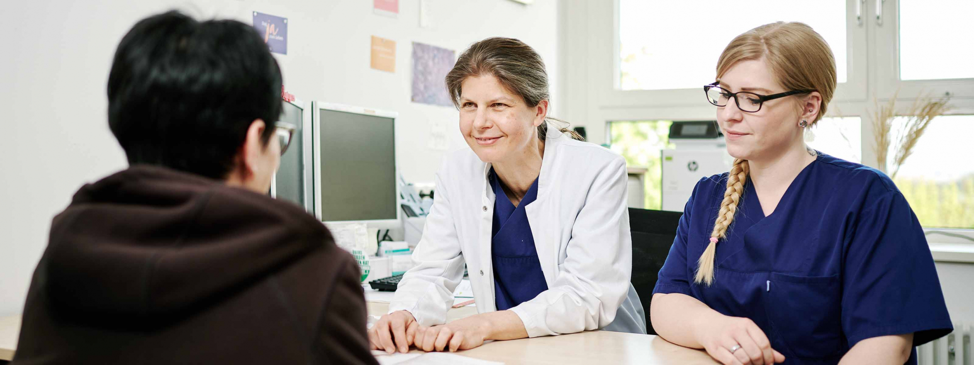 Ärztin und Patientenmanagerin beraten eine Patientin 